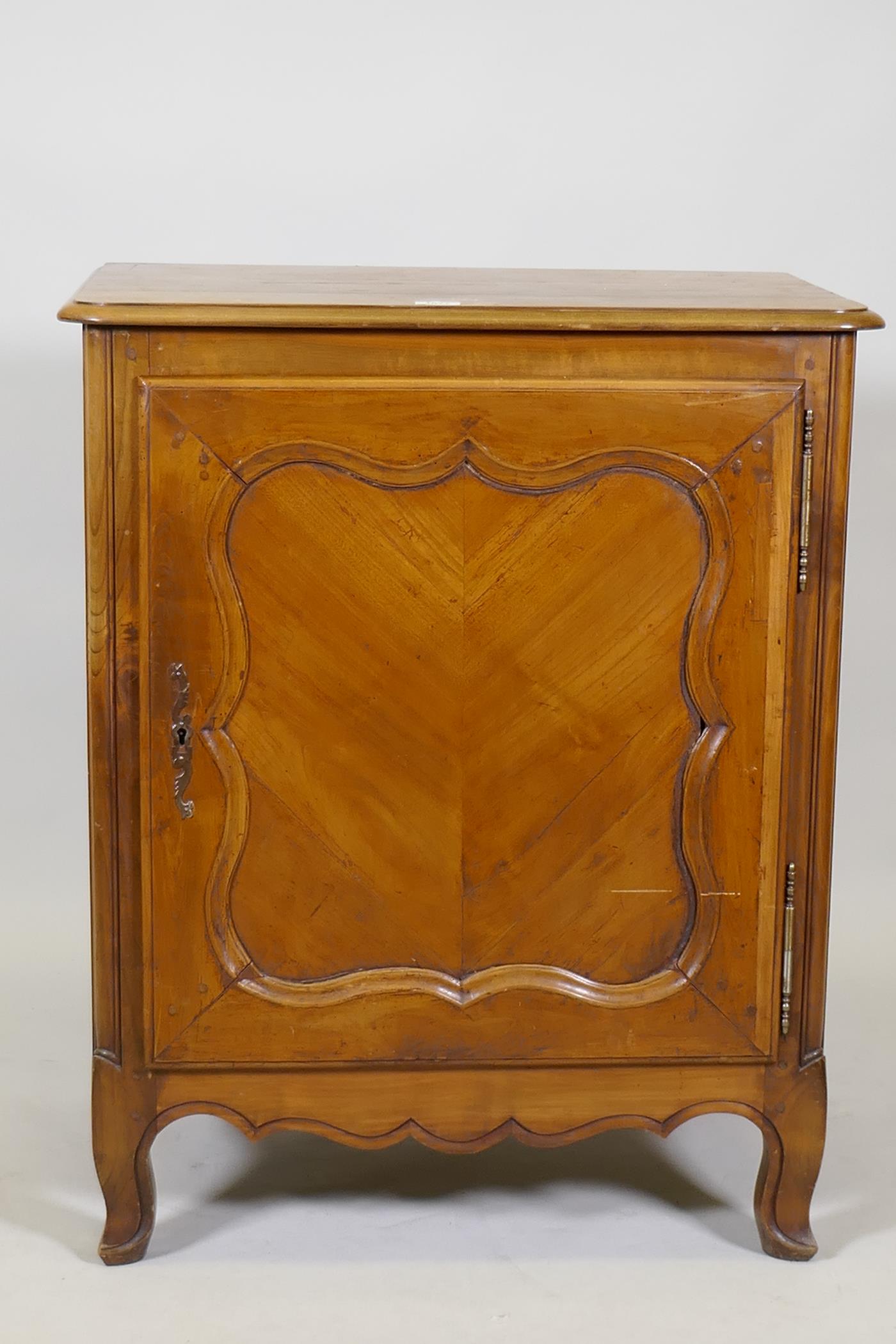 A C19th French side cabinet, with single door opening to reveal a shelf and two drawers, raised on