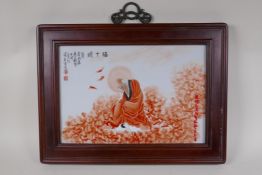 A Chinese red and white porcelain panel depicting Lohan, in a hardwood frame, 17½" x 13"