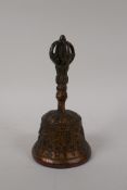 A Tibetan gilt bronze ceremonial bell with a vajra handle, 7" high