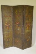 A C19th leather three fold screen with hand painted floral decoration, each panel 18" x 70"