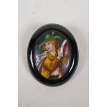 An antique European hand painted porcelain brooch depicting a tambourine player, 2" x 2½"