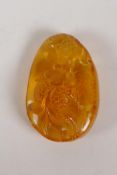 A Chinese amber pendant with carved goldfish decoration, 2"