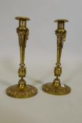 A pair of French Empire brass candlesticks with ram's mask decoration and tapering columns, 14" high