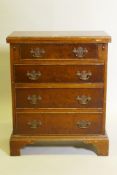 A yew wood veneered bachelor's chest, with fold out top over four drawers, raised on bracket