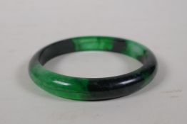 A Chinese bi-colour green hardstone bangle, 3" diameter