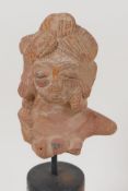 An Eastern terracotta head, 3" long, on turned stand