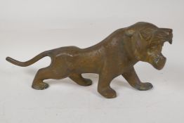 An Eastern stylised yellow metal figure of a lion, 15" long