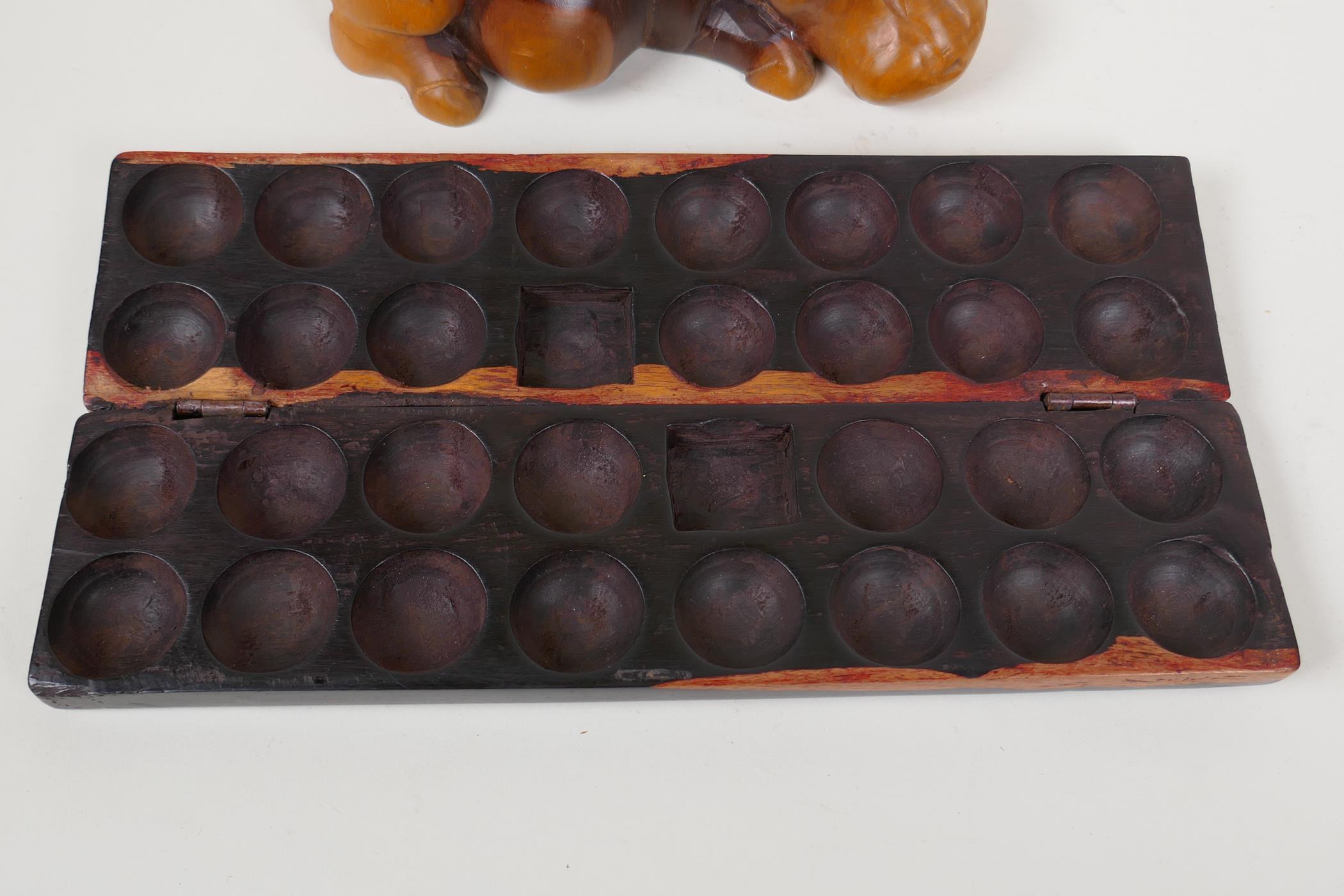 An African hardwood Bao Mancala board carved with rhinos, 13" long, and an African carved hardwood - Image 5 of 5