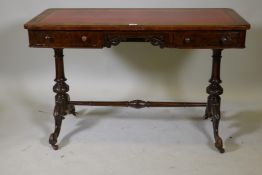 A Victorian figured walnut two drawer writing table, with leather inset top and open fretwork