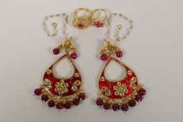 A pair of Indian gilt metal drop earrings with  semi precious red stone drops and enamelled