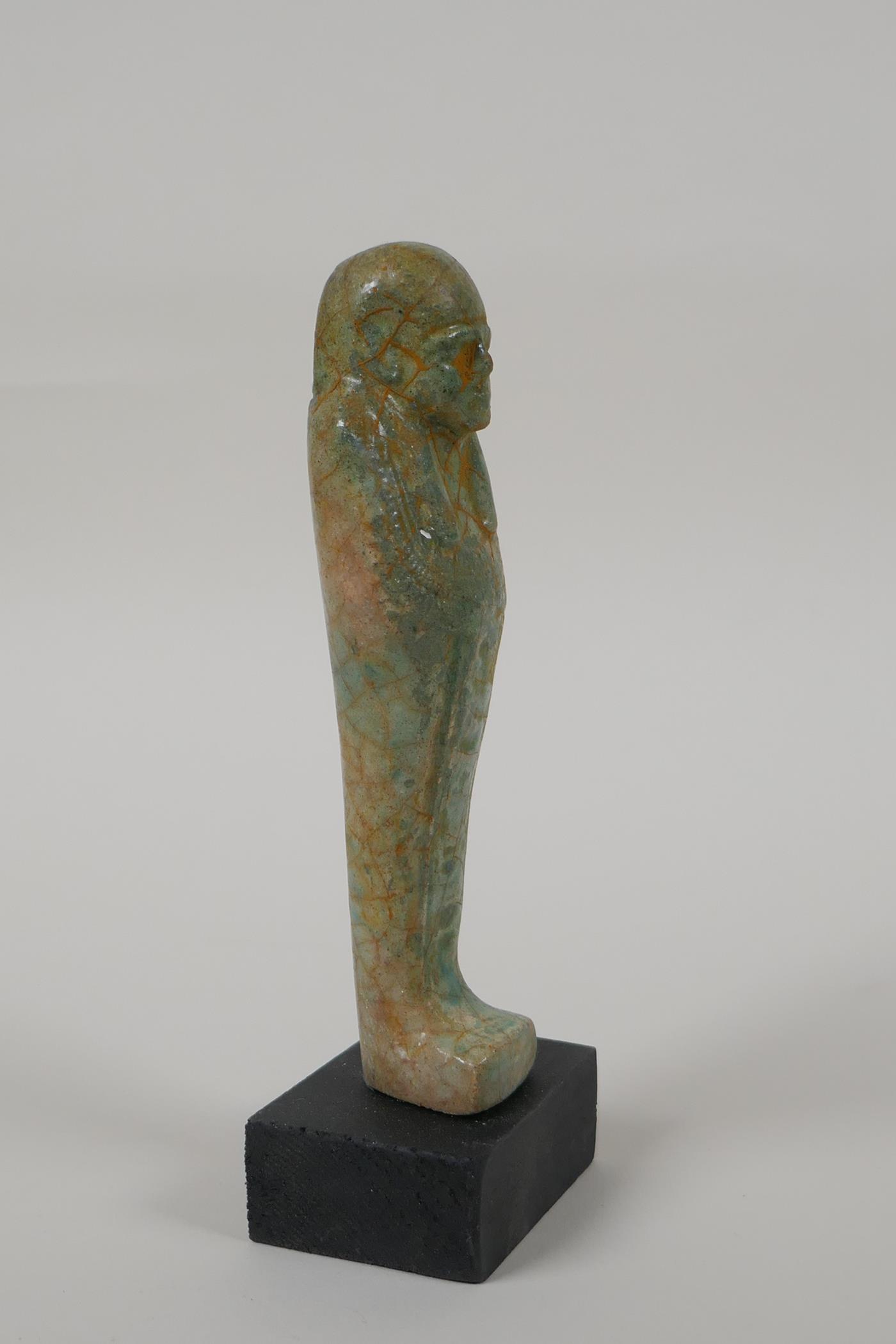 An Egyptian turquoise glazed faience shabti, mounted on a display base, 6" high - Image 2 of 4