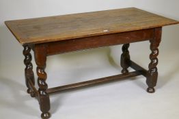 An antique oak refectory table, the plank top with cleated ends and sides, raised on barley twist