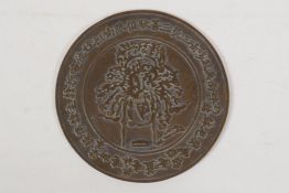 A Sino Tibetan bronze hand mirror, 4½" diameter