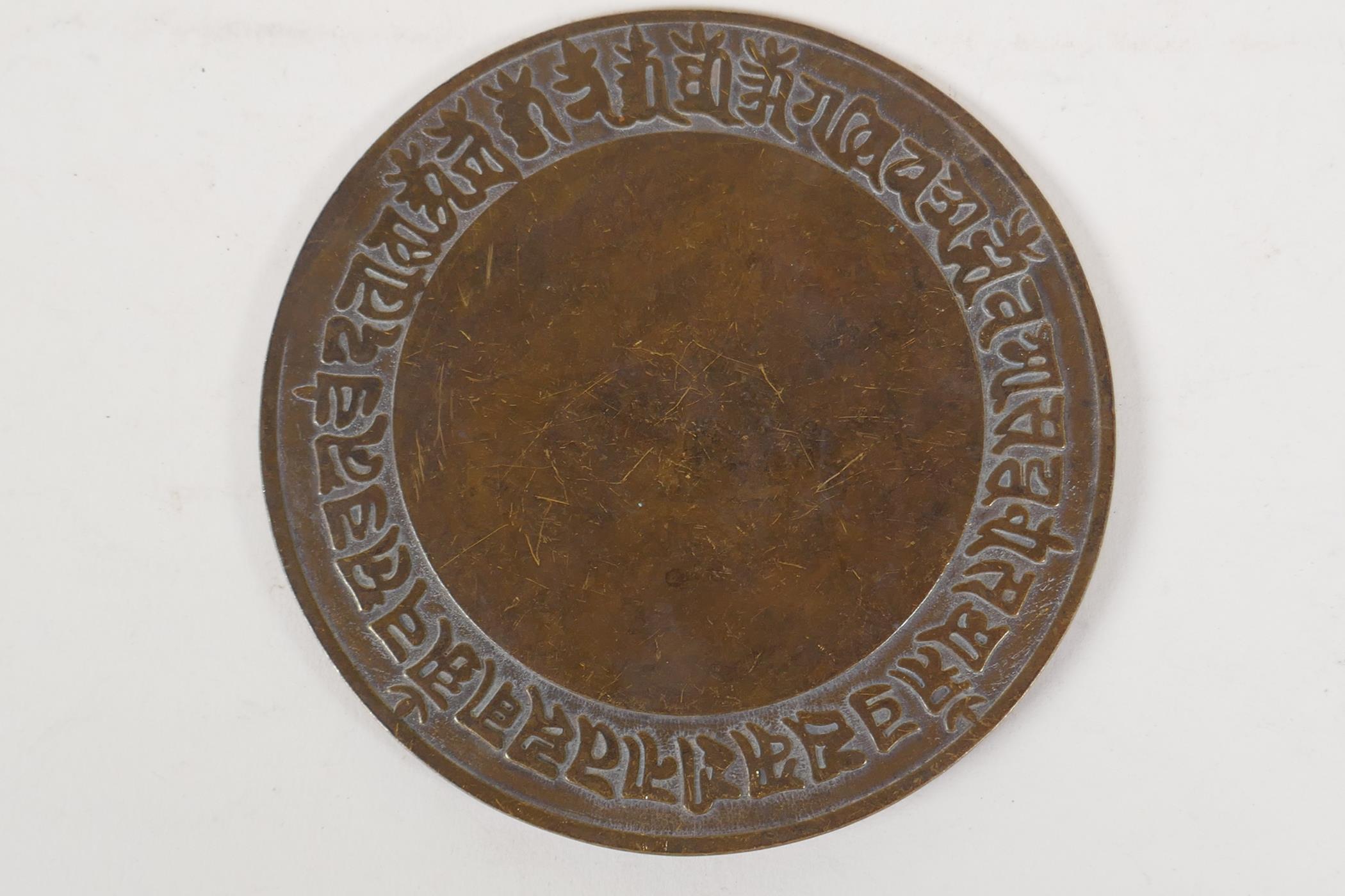 A Sino Tibetan bronze hand mirror, 4½" diameter - Image 2 of 2