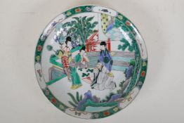 A famille vert porcelain charger decorated with figures in a garden, Chinese KangXi 6 character mark