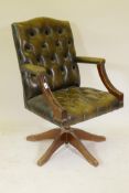 A tilt and swivel desk chair with button leather upholstery and brass stud decoration