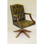 A tilt and swivel desk chair with button leather upholstery and brass stud decoration