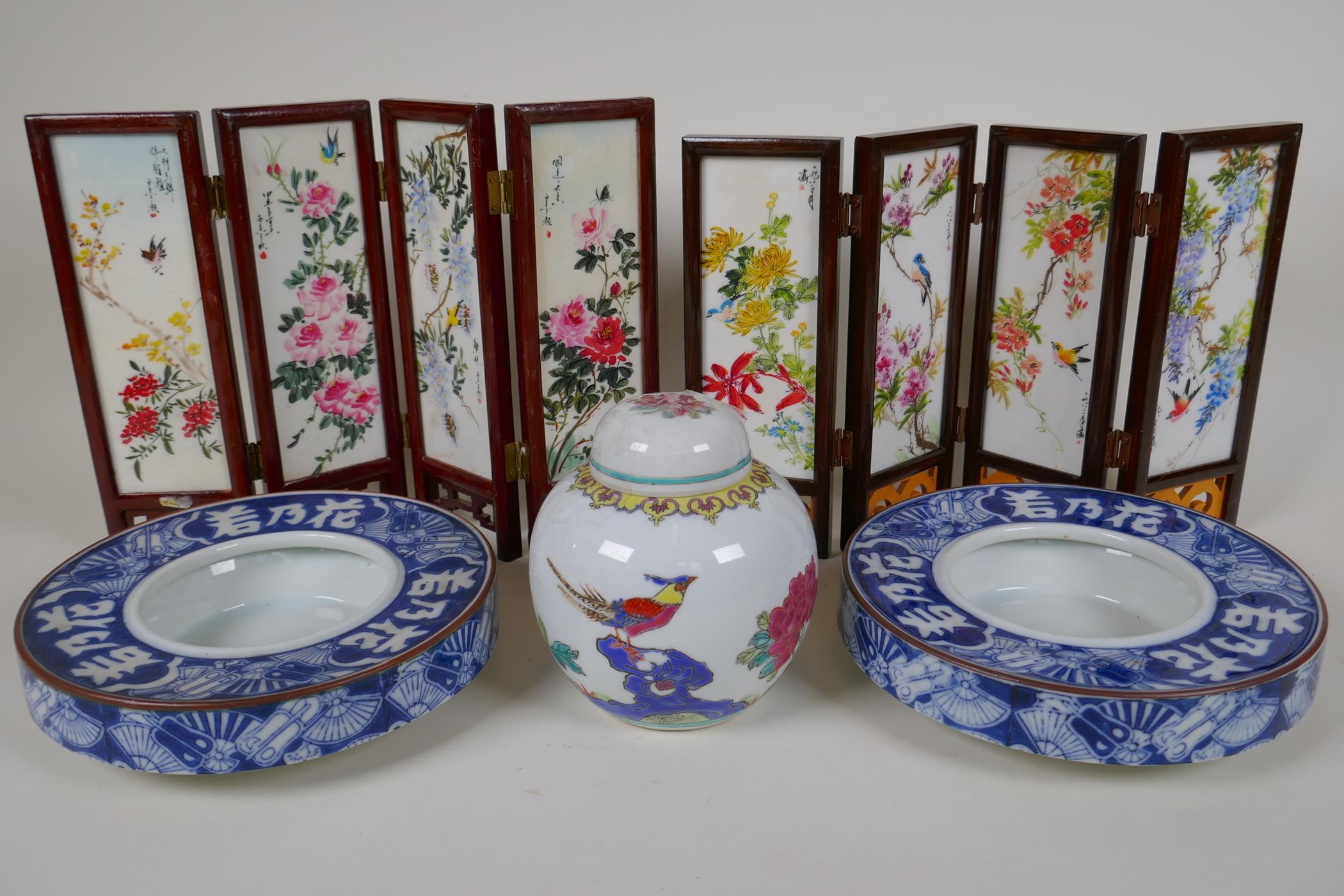 A pair of Japanese blue and white porcelain shallow bowls decorated with fans and characters, 7"