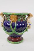 A Majolica pedestal jardiniere with two hoofed cherub handles and lion's mask supported garlands,