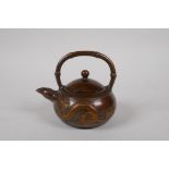 A Chinese bronze teapot of squat form with bamboo style handle and spout, and dragon decoration,