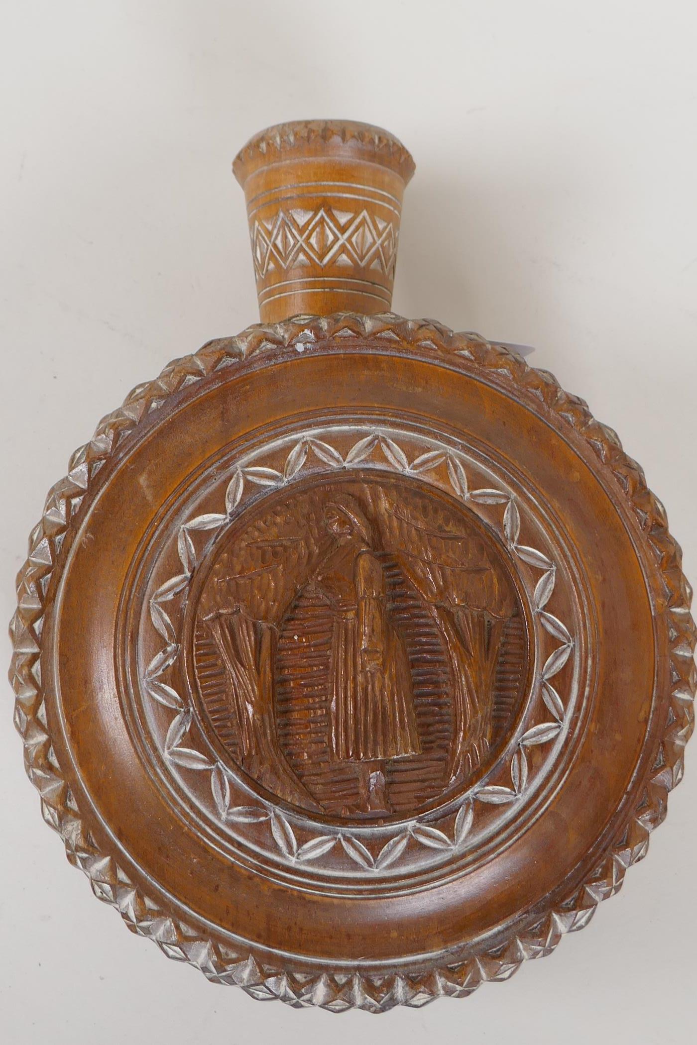 A Continental carved wood cased wine flask carved with male and female figures, 6½" diameter