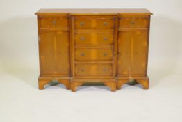 A small yew wood breakfront side cabinet with three drawers over two cupboards flanking a flight