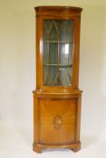 A satinwood bow fronted standing corner display cabinet, with astragal glazed door over a cupboard