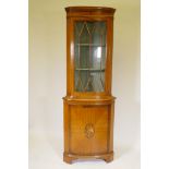 A satinwood bow fronted standing corner display cabinet, with astragal glazed door over a cupboard