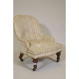 A Victorian child's nursing chair, raised on turned supports and brass castors, 25" high