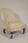 A Victorian child's nursing chair, raised on turned supports and brass castors, 25" high