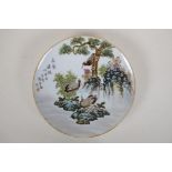 A Chinese polychrome porcelain cabinet plate decorated with cranes on a river bank, character