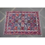 An old full pile Persian Bakhtiari village rug with a panelled design, dated/signed?, 66" x 95"