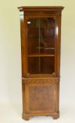 A good yew wood corner display cabinet, with upper glazed door over a sea scroll frieze and single