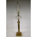 An Empire style brass Corinthian column table lamp with a decorative glass reservoir, 37" high