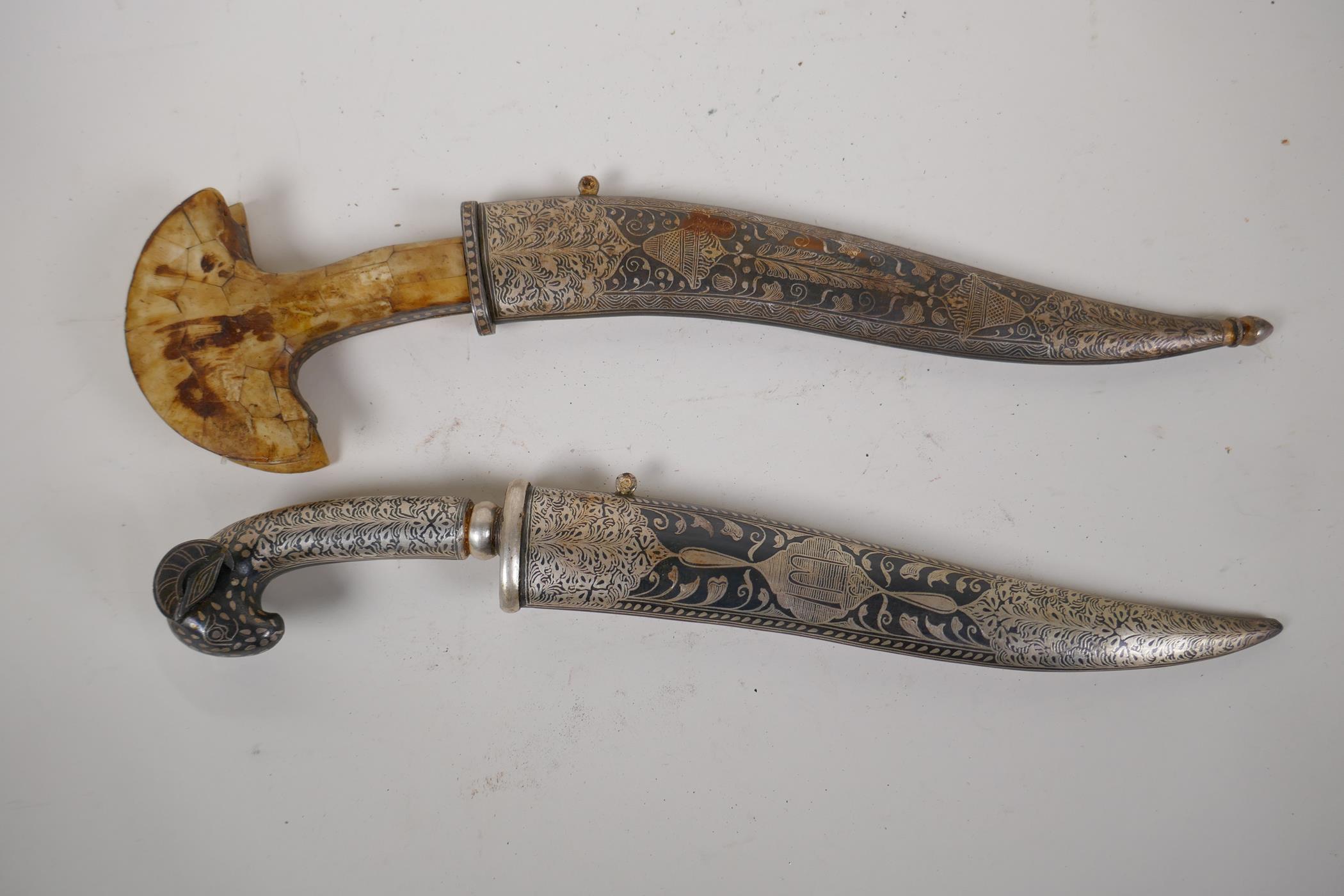 An Eastern dagger with rams mask handle and niello decorated scabbard, 15" long, and a horn