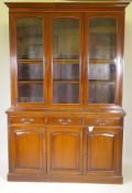 A large C19th mahogany cabinet bookcase, the upper section with three glazed doors over shelves, the