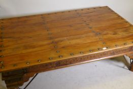A large Indian coffee table, with iron mounts and brackets and carved frieze, 45" x 71" x 21"