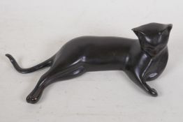 A bronze figure of a reclining Siamese cat, 12" wide