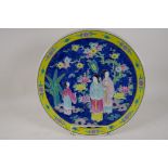 A Chinese porcelain charger painted in bright enamels with a lady and her servants, 16" diameter