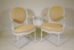 A pair of open arm tub shaped chairs, with spoon backs, raised on turned supports, later painted,