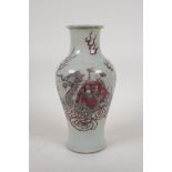 An early C20th red and white porcelain vase decorated with an immortal riding a dragon, 10" high