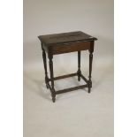 An antique oak side table, with carved top, raised on turned supports united by stretchers, bears