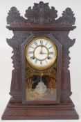 An American 'ginger bread' mantel clock with striking movement on a gong, white enamel dial and