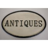 An oval cast iron 'Antiques' sign 13½" x 8½"