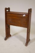 An Arts and Crafts style oak magazine rack with inlaid decoration raised on pierced end supports,