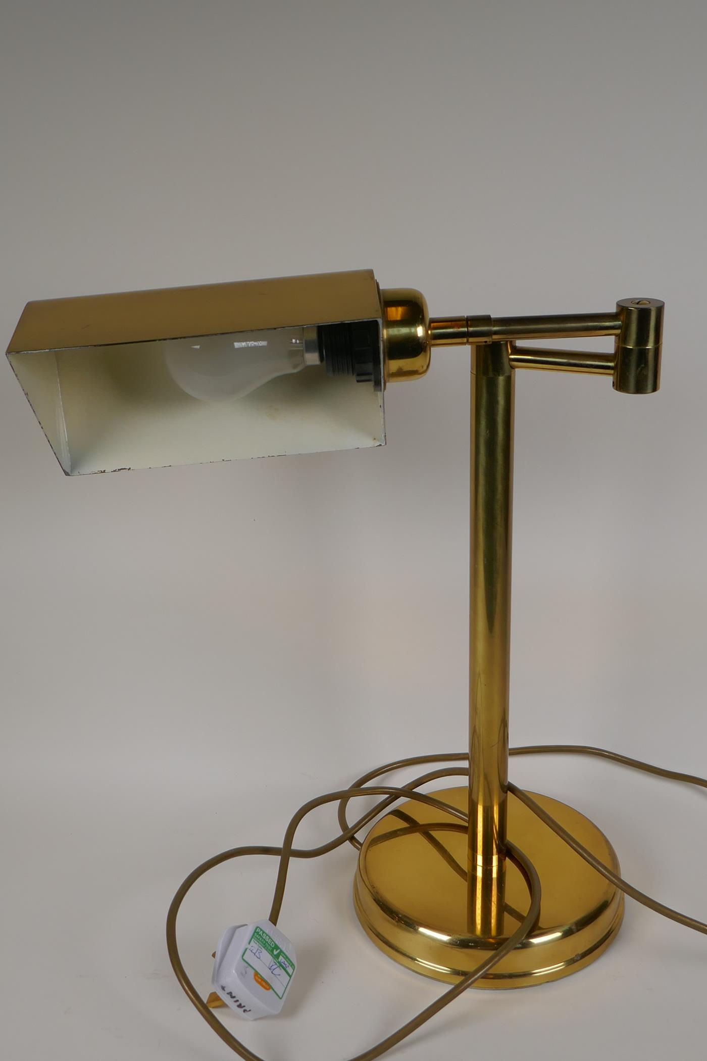 An adjustable brass desk lamp on a tubular column, 17" high