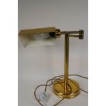 An adjustable brass desk lamp on a tubular column, 17" high