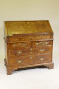 An C18th feather banded and figured walnut fall front bureau, the stepped interior with concave