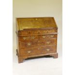 An C18th feather banded and figured walnut fall front bureau, the stepped interior with concave