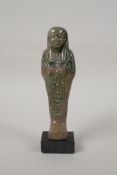 An Egyptian turquoise glazed faience shabti, mounted on a display base, 7" high